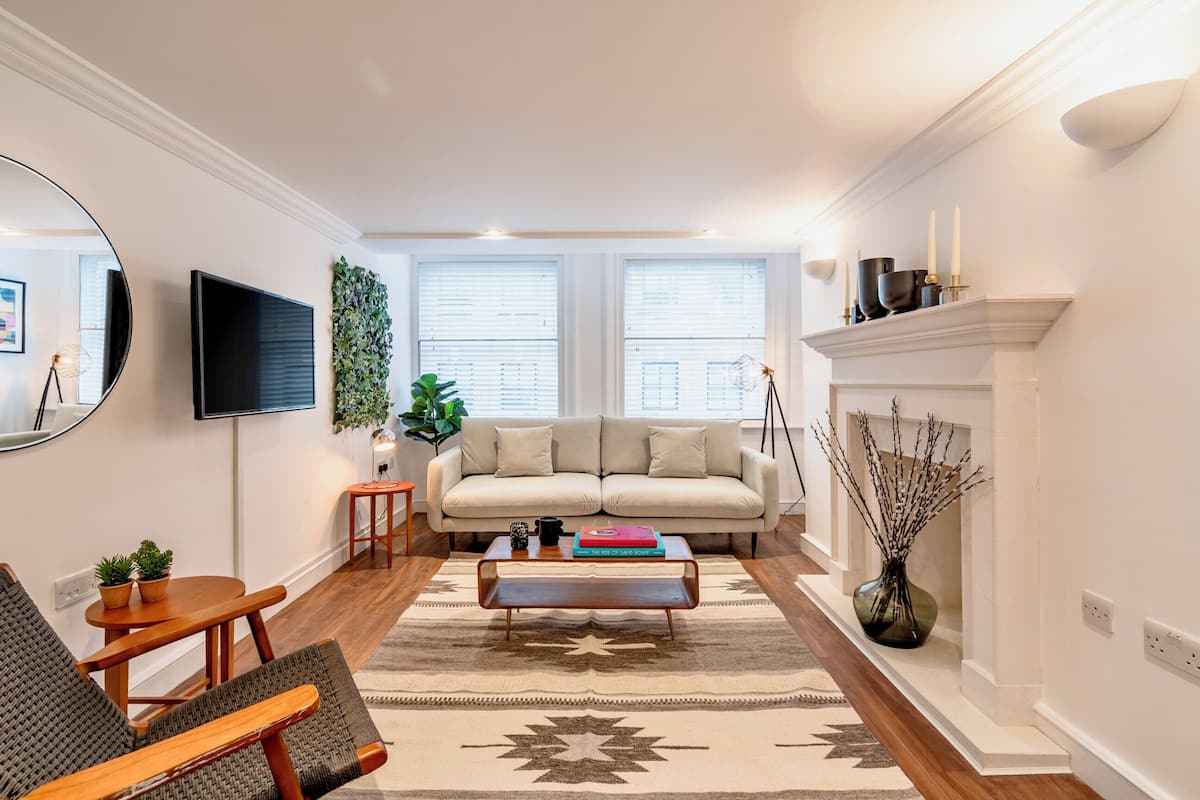 A living room with a sofa, coffee table, and a fireplace.