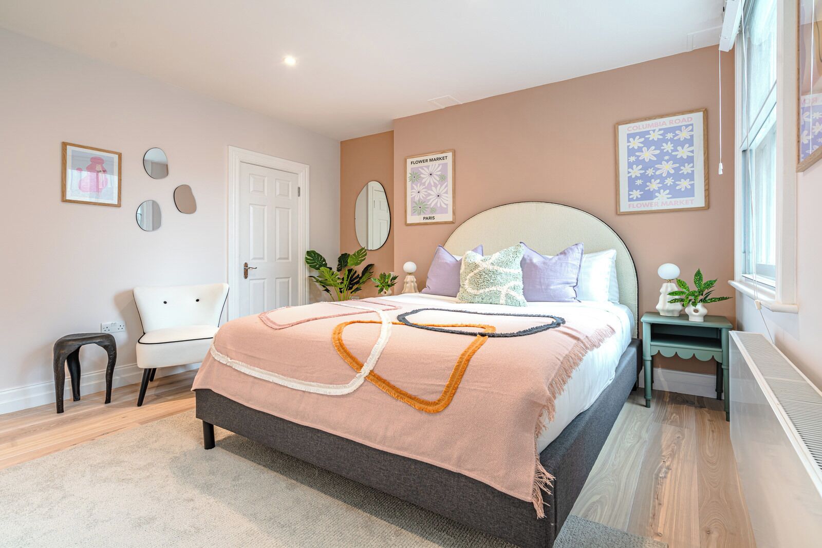 Une chambre à coucher avec un grand lit, une table de chevet, une chaise et un bureau.