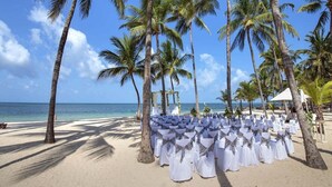 Aan een privéstrand, wit zand, ligstoelen, parasols