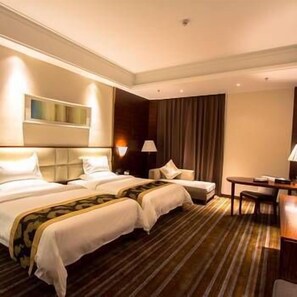 A hotel room with two beds, a desk, and a chair. - Delin Hotel (Shenzhen)