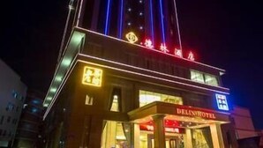 A hotel with a prominent sign reading "DELINHOTEL" and a brightly lit facade with vertical blue lights. - Delin Hotel (Shenzhen)