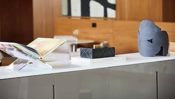 A modern reception desk with a magazine, a black box labeled 'STUDIO KO', and a sculptural object.