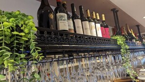A wine rack with bottles and glasses. - The Coach House Inn (Chester)