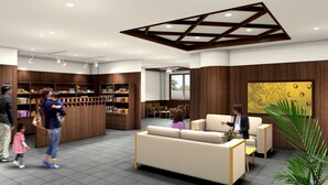 Un vestíbulo moderno con mostrador de recepción, zona de estar y estanterías de madera con productos.