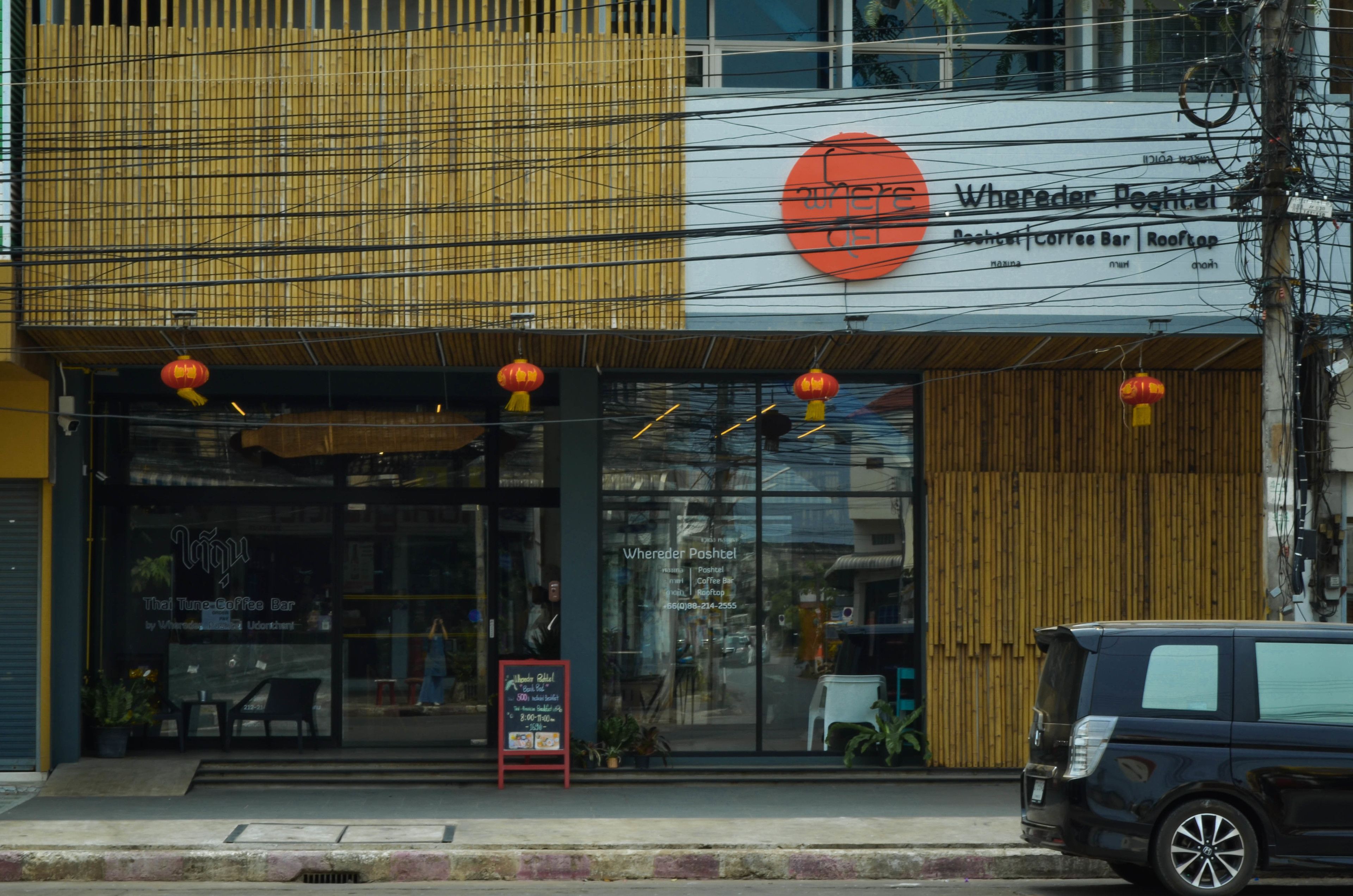 Una cafetería con fachada moderna, grandes ventanales y terraza.
