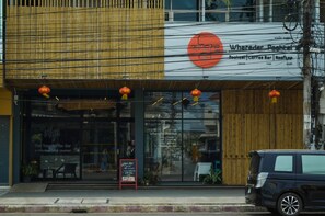 A coffee shop with a modern facade, large glass windows, and outdoor seating.