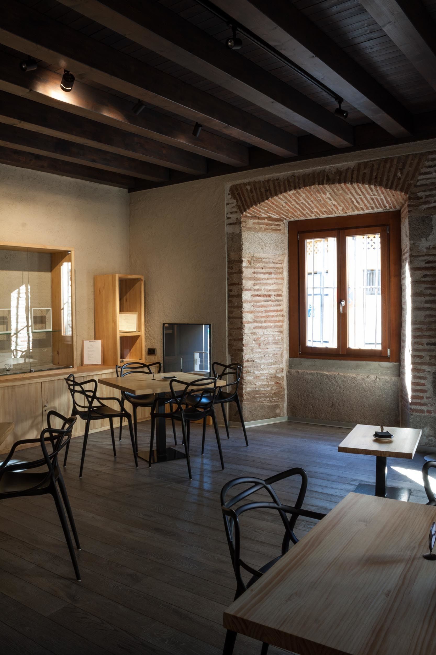 Una cocina moderna con armarios de madera, un refrigerador y un comedor con sillas y una mesa.