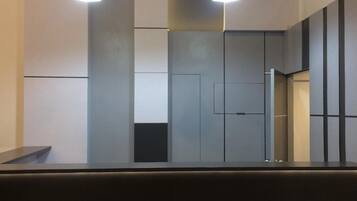 A modern interior with two pendant lights, a dark counter, and a minimalist wall design.