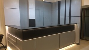 A modern kitchen with a sleek countertop, integrated lighting, and a minimalist design. - UD House (Udon Thani)