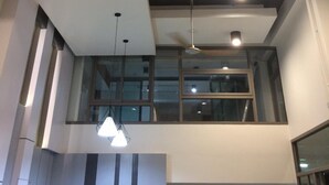A modern interior with a ceiling fan, recessed lighting, and a glass balcony. - UD House (Udon Thani)