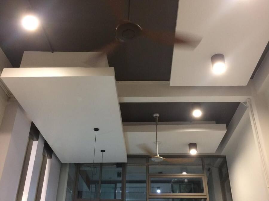 A modern interior with a ceiling fan, recessed lighting, and a glass balcony.