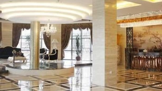 A spacious lobby with a high ceiling, a chandelier, and a large window. - Junlin Dongfang Hotel (Zhenjiang)