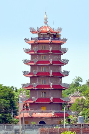 A multi-tiered pagoda-style building with a traditional architectural design, featuring multiple eaves and a central spire. - Hotel Bodh Vilas (Gaya)