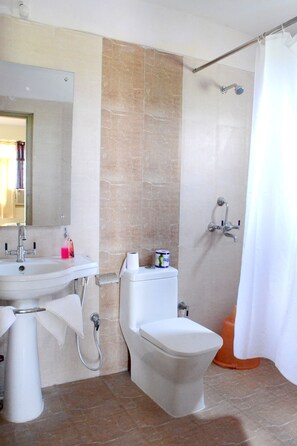 A bathroom with a sink, toilet, and shower. - Hotel Bodh Vilas (Gaya)
