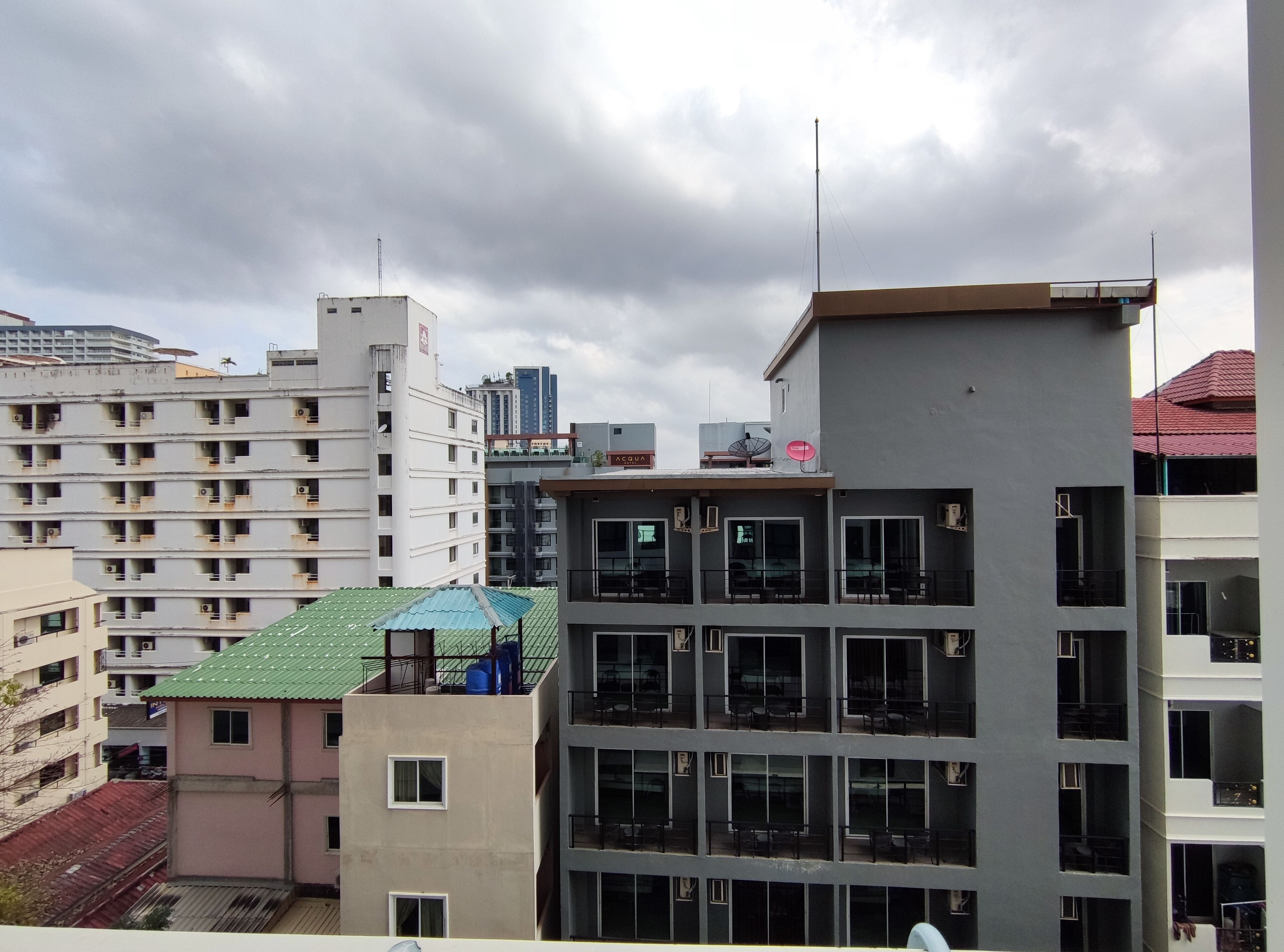 A multi-story building with balconies and large windows.