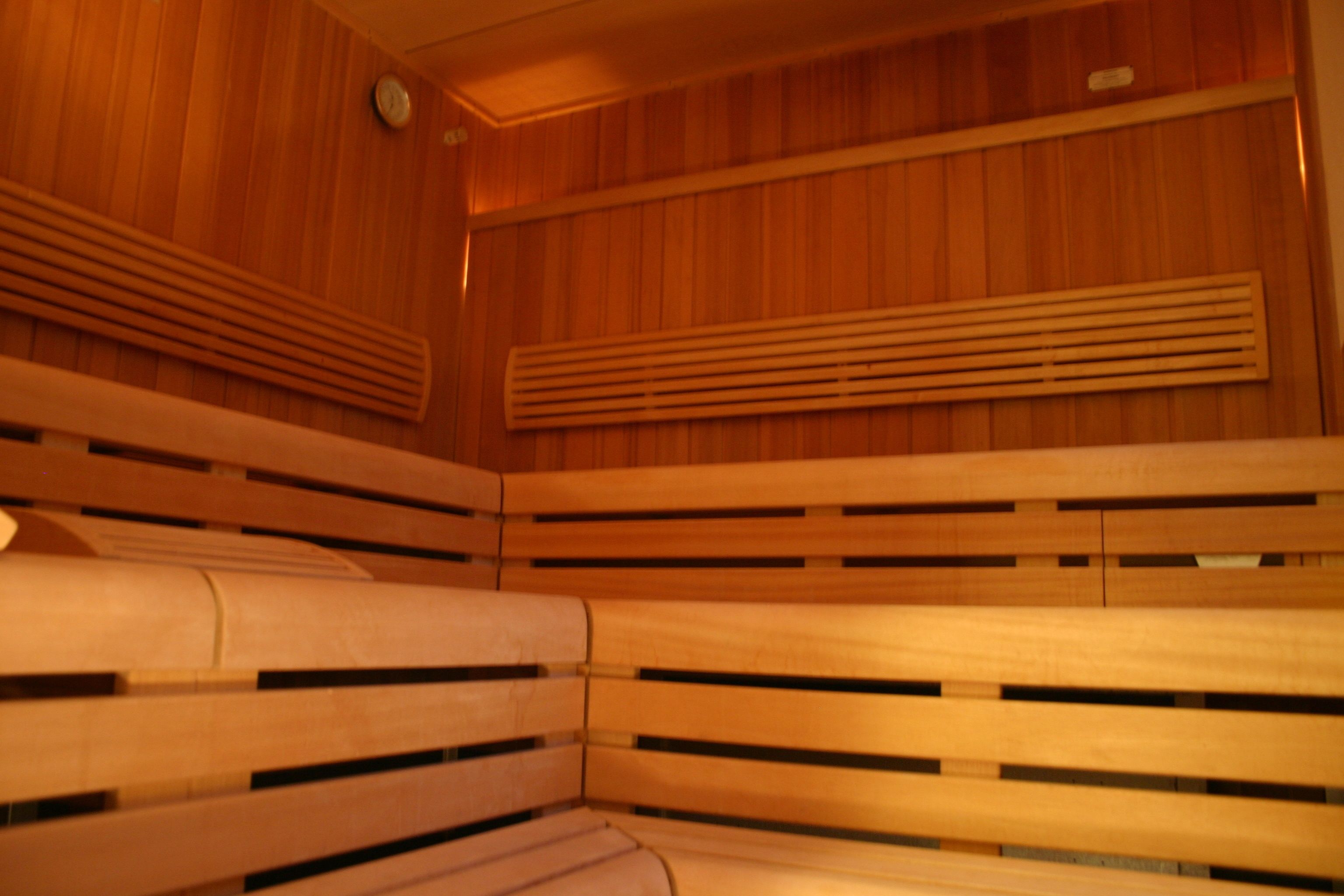 Una sauna con bancos de madera y paredes de listones.