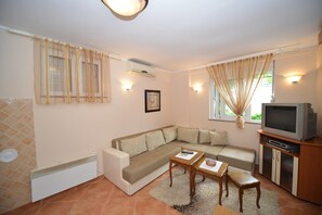 Departamento, 1 habitación, Terraza, vista al mar | Área de sala de estar | Televisión de pantalla plana 