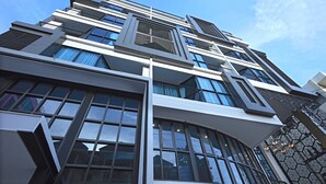 Um edifício moderno com vários andares, grandes janelas e fachada geométrica.