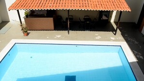 A rectangular swimming pool with a tiled edge, a small drain in the center, and a metal ladder on the side. - Hotel Sambaquis (São Luís)