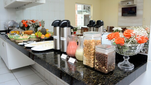 A buffet counter with various food items and beverages. - Hotel Sambaquis (São Luís)
