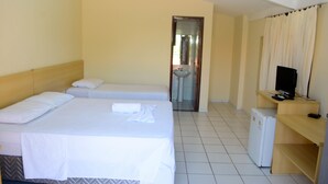 A hotel room with two beds, a small refrigerator, a television on a wooden stand, and a bathroom visible through an open door. - Hotel Sambaquis (São Luís)