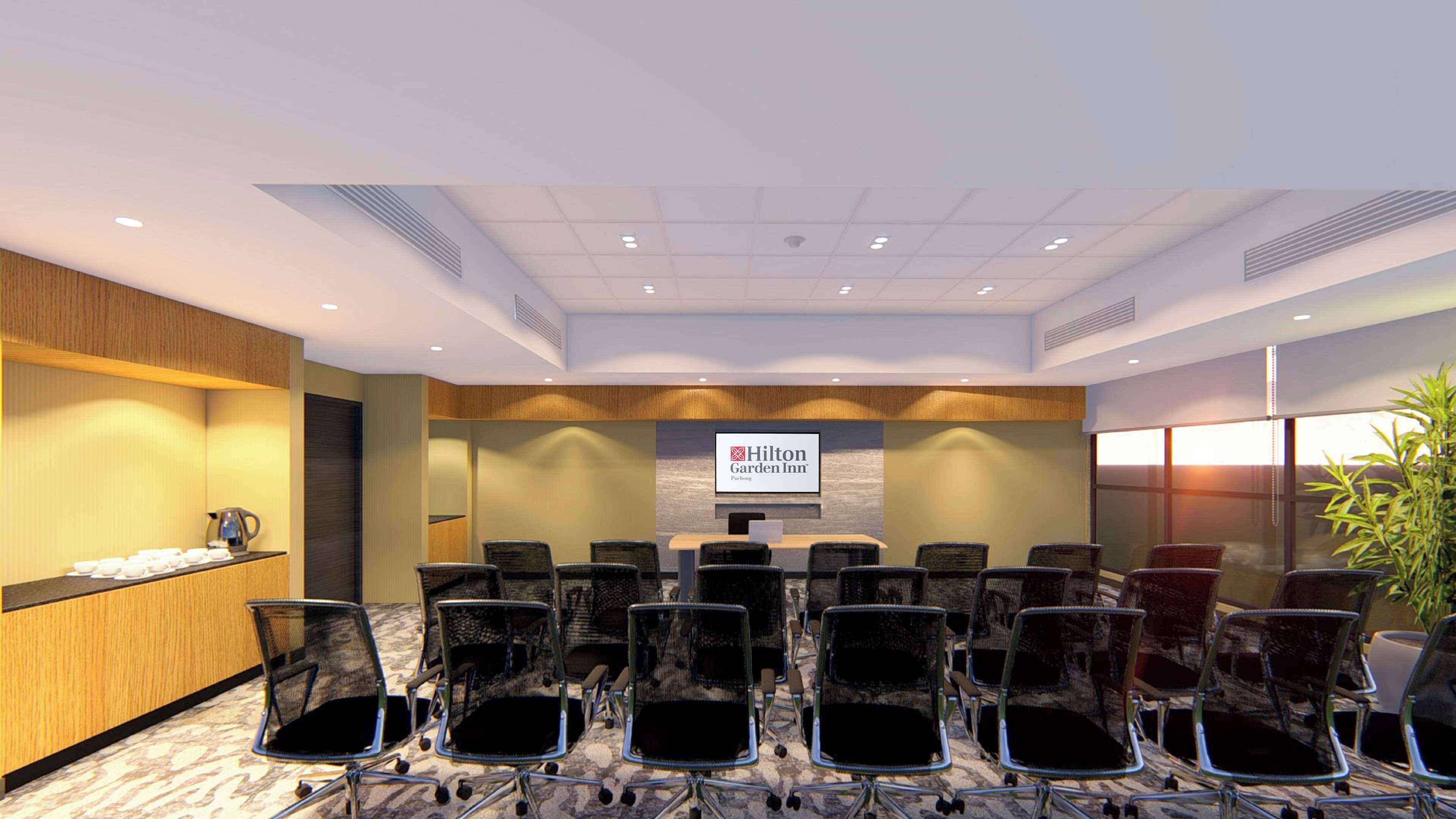 A conference room with a Hilton Garden Inn sign, a buffet counter, and a large window with a view.