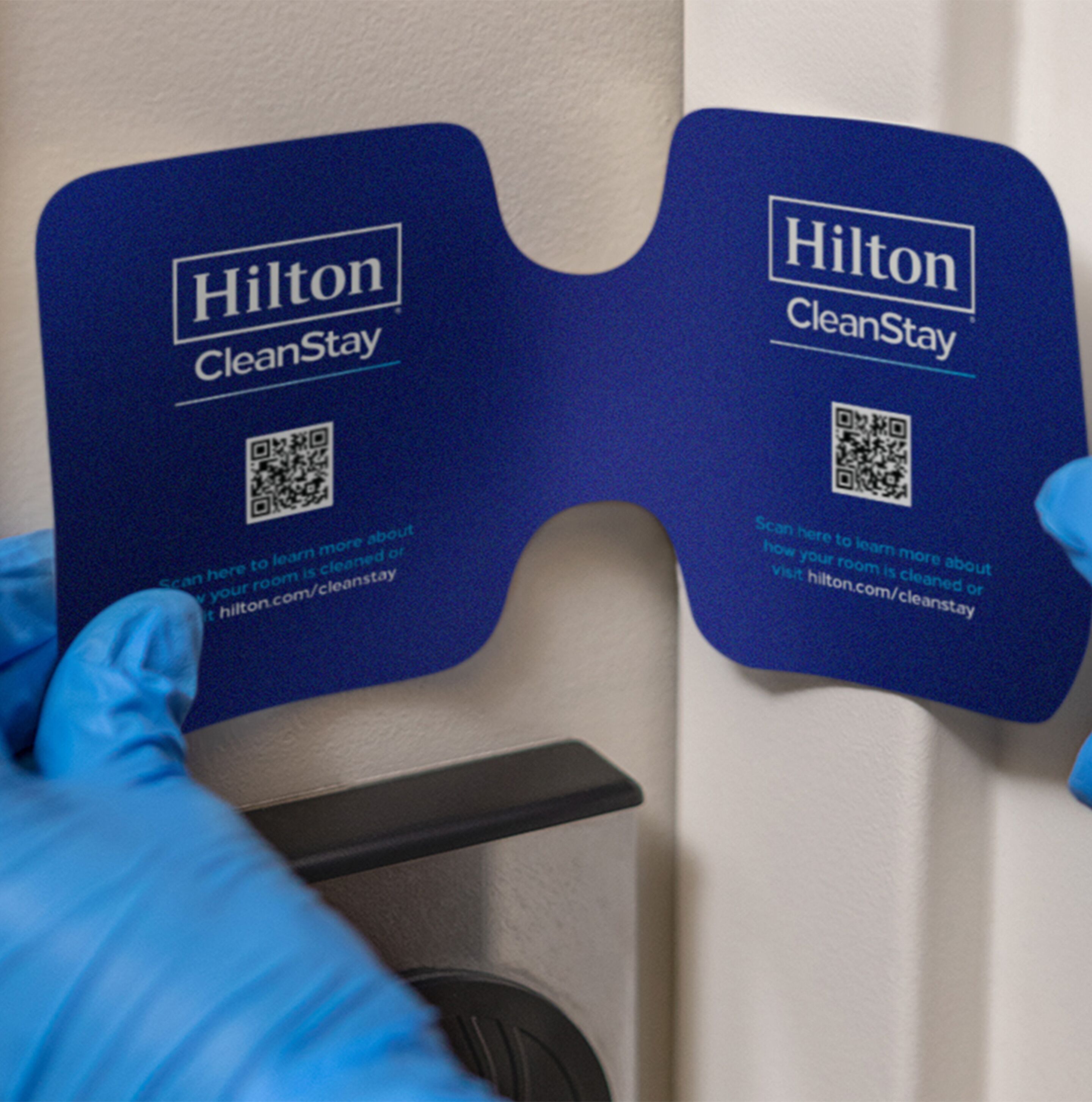 Two blue Hilton CleanStay cards with QR codes and instructions for guests to scan for more information about room cleanliness.