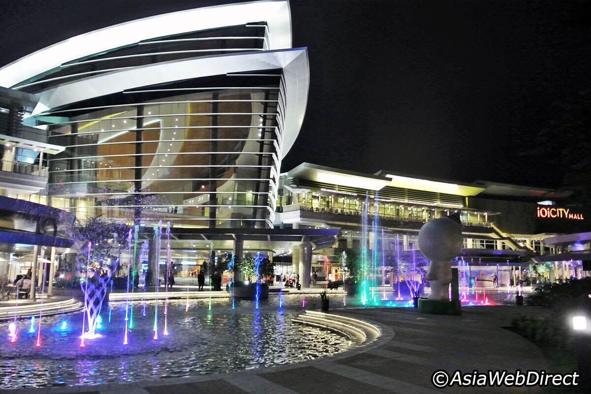 A modern building with a curved facade and a water feature in front.