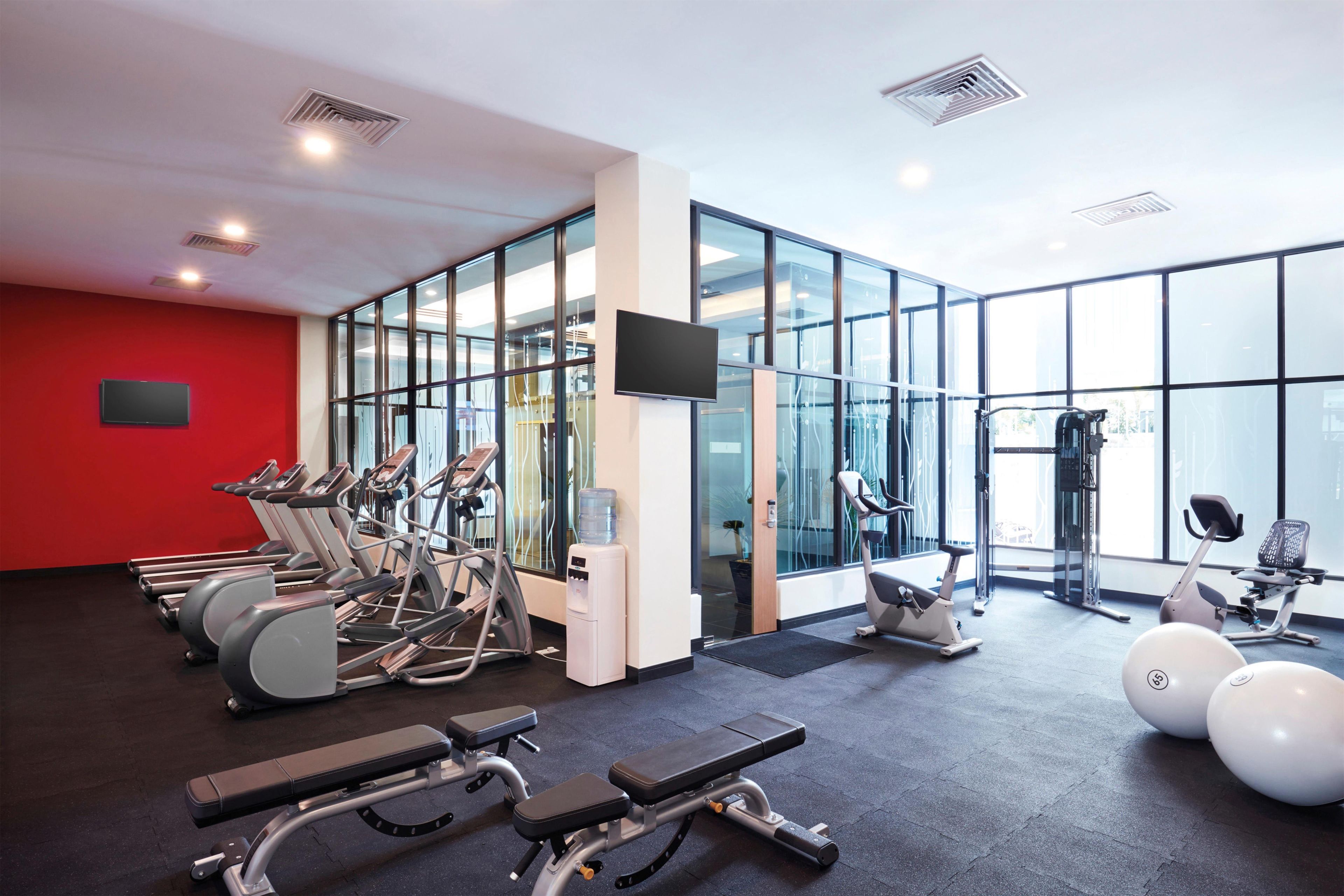 A gym with treadmills, elliptical machines, and weightlifting equipment.