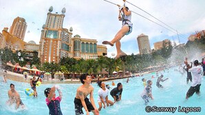 A water park with a zip line attraction, pools, and a cityscape in the background. - Hilton Garden Inn Puchong (Puchong)