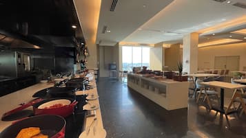Una cocina moderna con una encimera larga, utensilios de cocina y vistas a la ciudad.