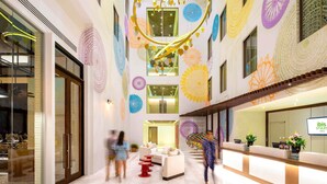 Un hall d’hôtel au design moderne, comprenant un comptoir d’accueil, un espace salon et des éléments décoratifs au plafond.