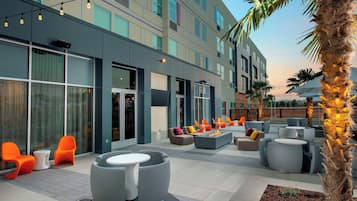 Un área de estar al aire libre con muebles modernos y un brasero.