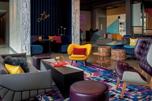 A modern lounge area with sofas, armchairs, and a coffee table. - Aloft by Marriott Dublin-Pleasanton (Dublin)
