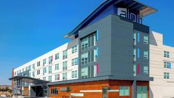 Un hotel moderno con techo plano, numerosas ventanas y un acceso cubierto.