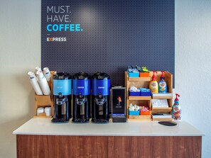 A coffee station with multiple coffee dispensers, a water cooler, and a variety of coffee-related products on shelves. - Holiday Inn Express & Suites Oklahoma City Airport by IHG (Oklahoma City)