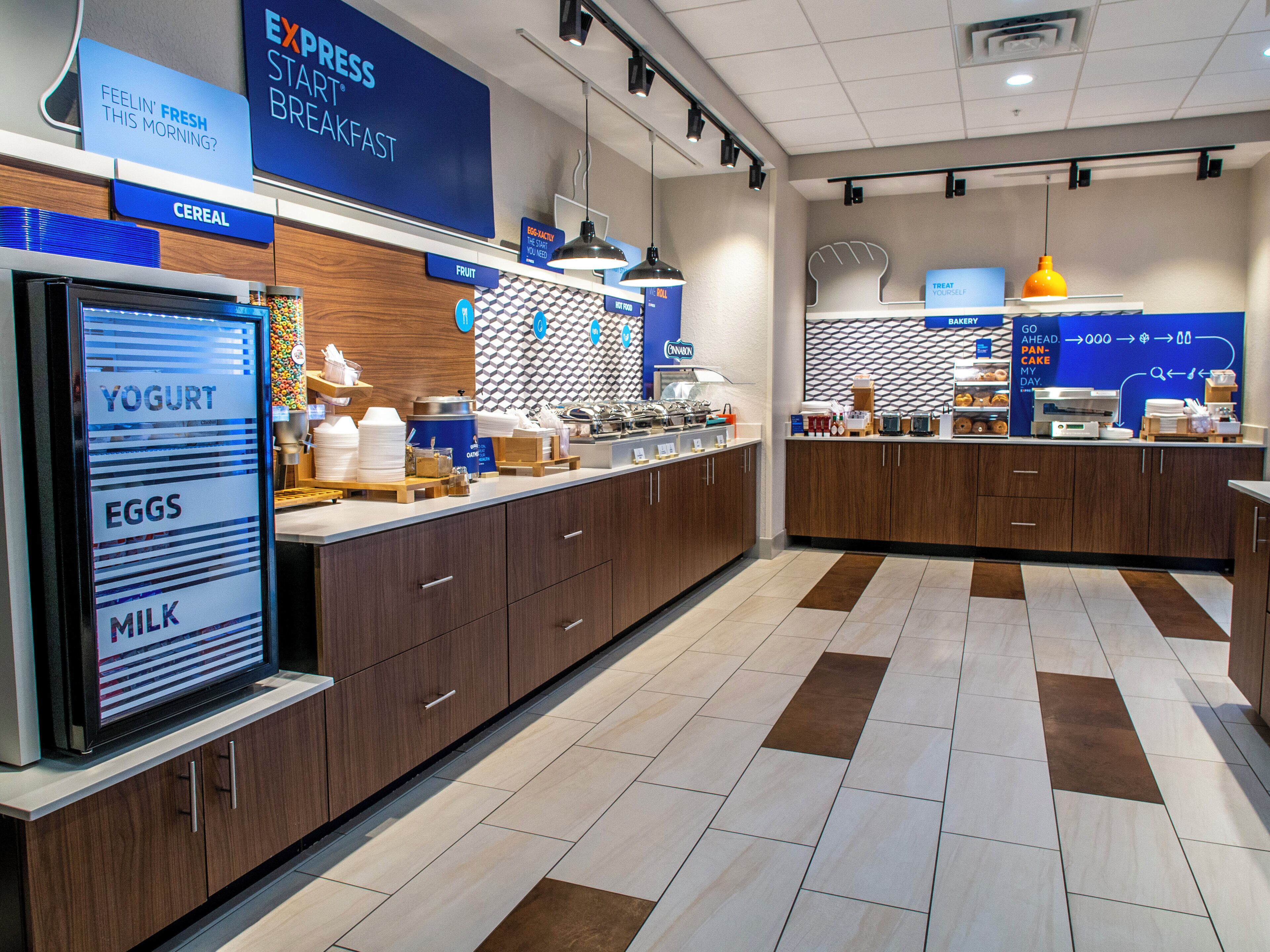 A breakfast buffet area with labeled sections for yogurt, eggs, and milk.