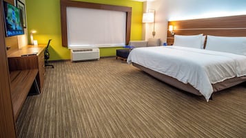 Une chambre d’hôtel avec un lit, un bureau, une chaise et une grande fenêtre.