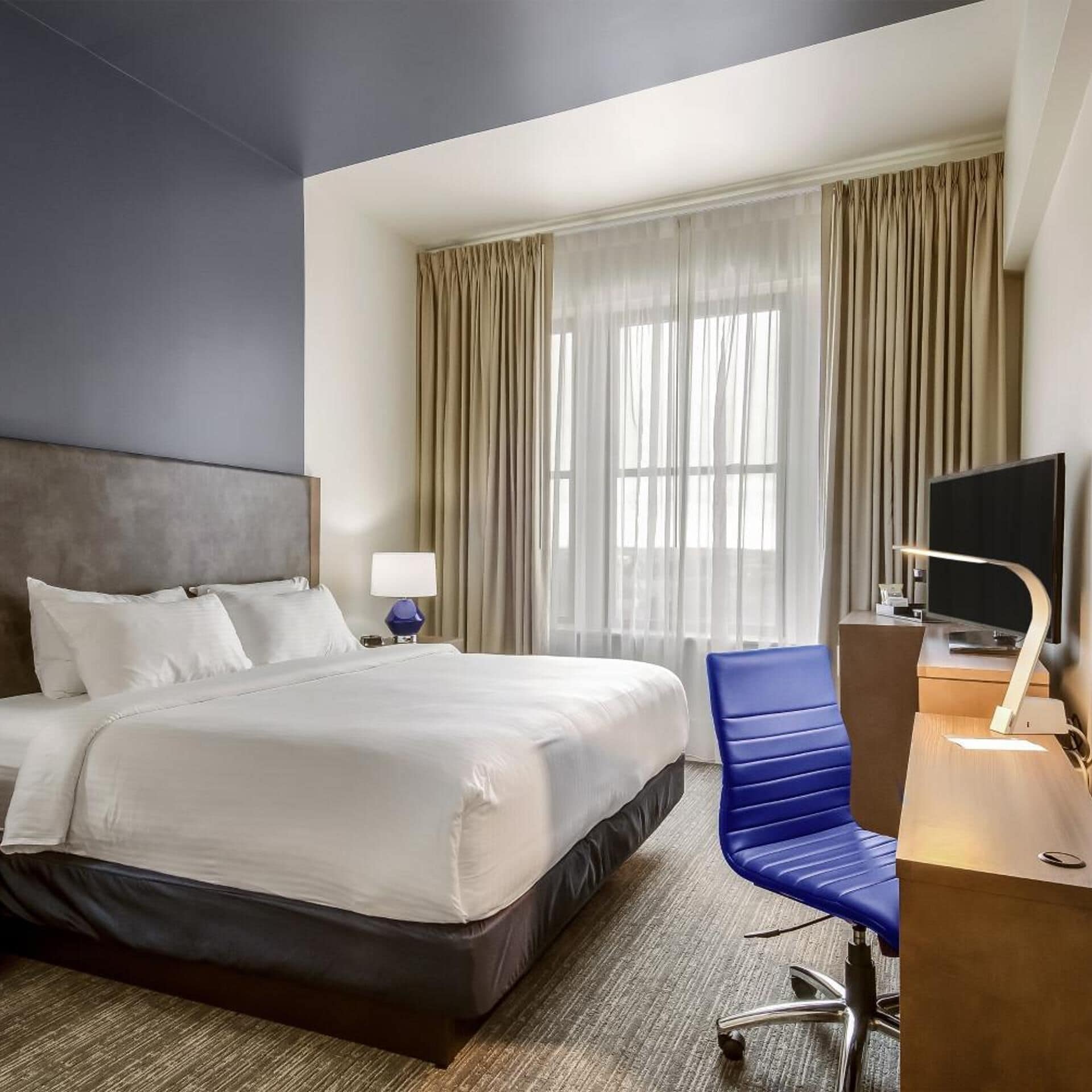 Premium bedding, desk, laptop workspace, blackout drapes