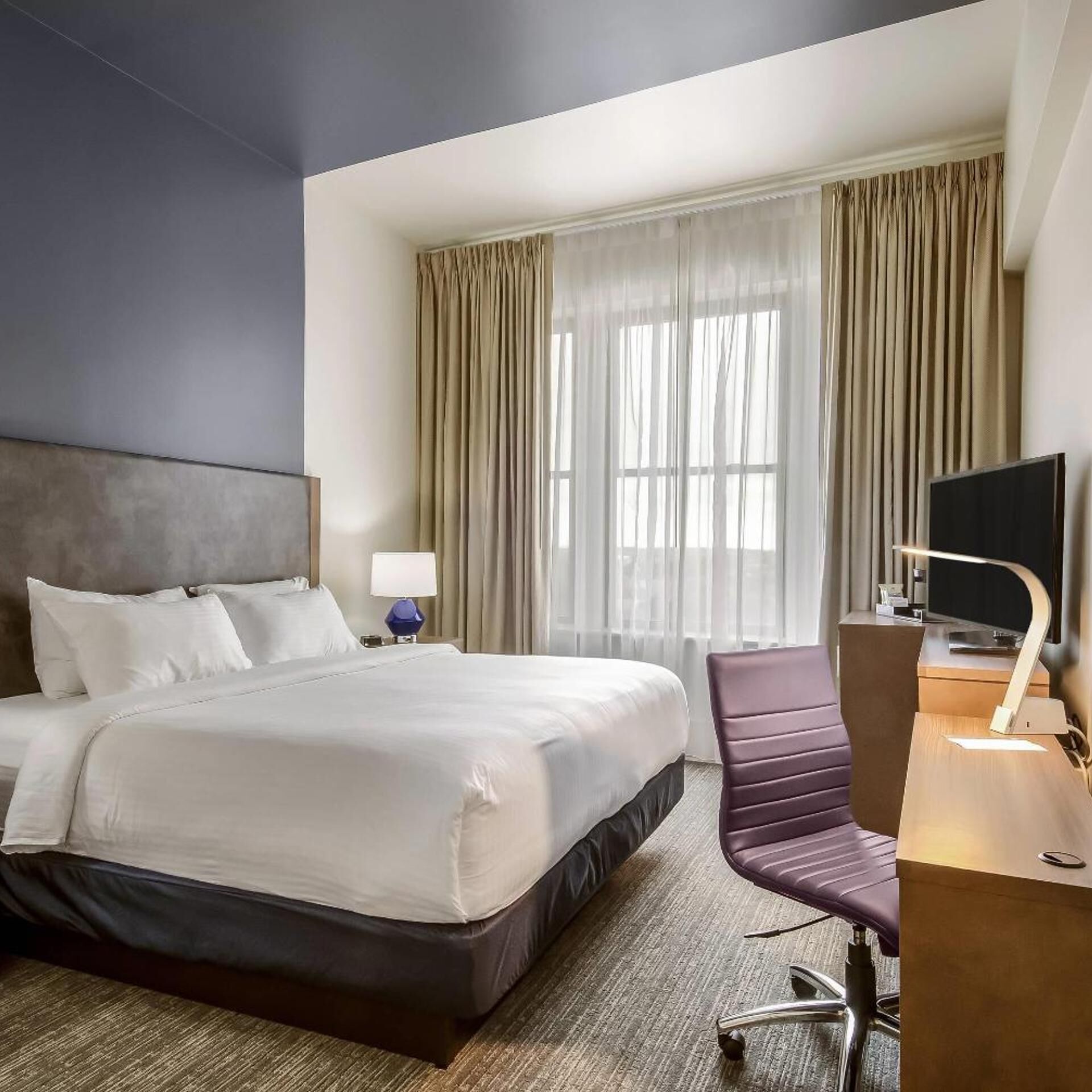Premium bedding, desk, laptop workspace, blackout curtains