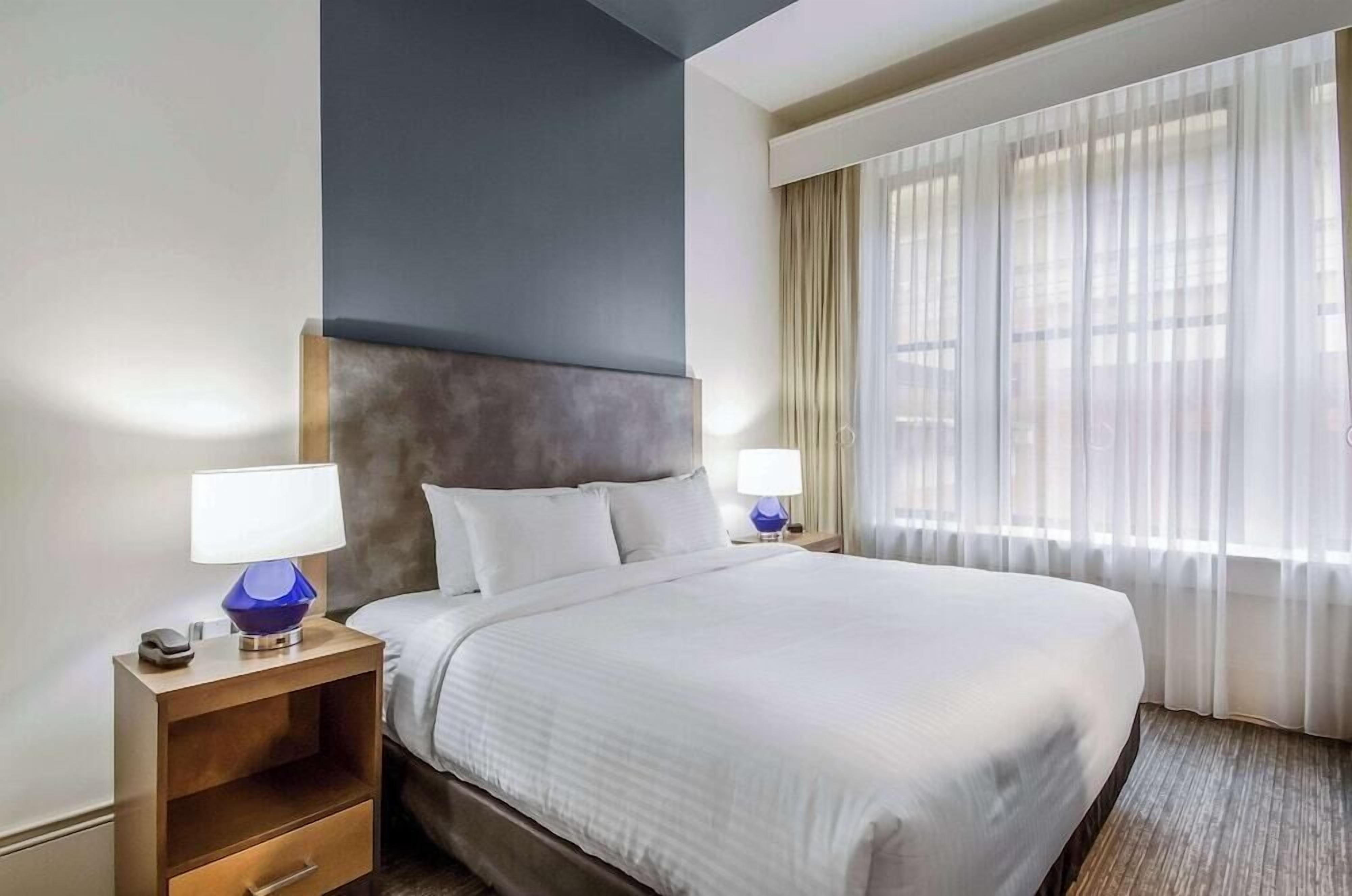 Premium bedding, desk, laptop workspace, blackout drapes