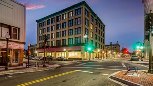 A corner building with a green awning, a visible fire hydrant, and a street intersection with traffic lights. - New Bedford Harbor Hotel (New Bedford)