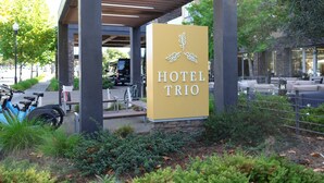 A hotel sign with the name "HOTEL TRIO" and a logo of three leaves. - Hotel Trio Healdsburg (Healdsburg)