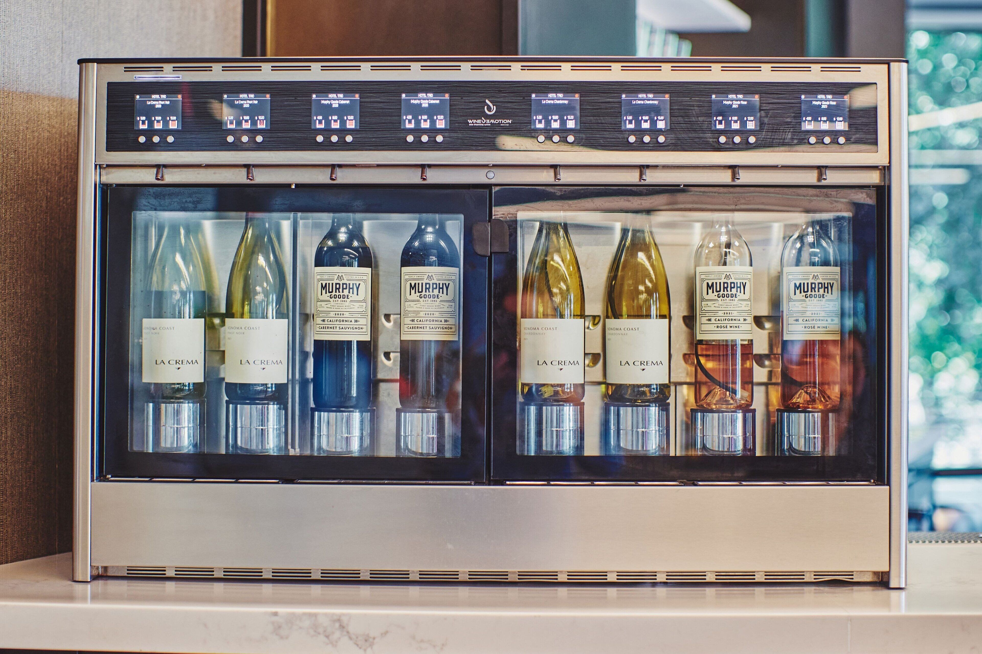 A wine refrigerator with multiple bottles of Murphy Goode and La Crema wines.