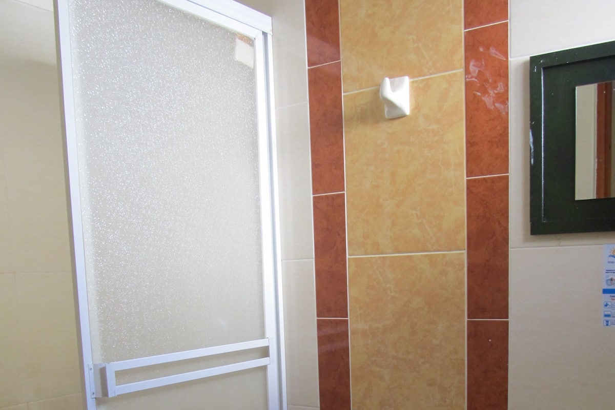 Un baño con inodoro, lavamanos y cabina de ducha.