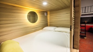 Ein Einzelbett mit einer runden Wandverkleidung und einer roten Wand im Hintergrund.