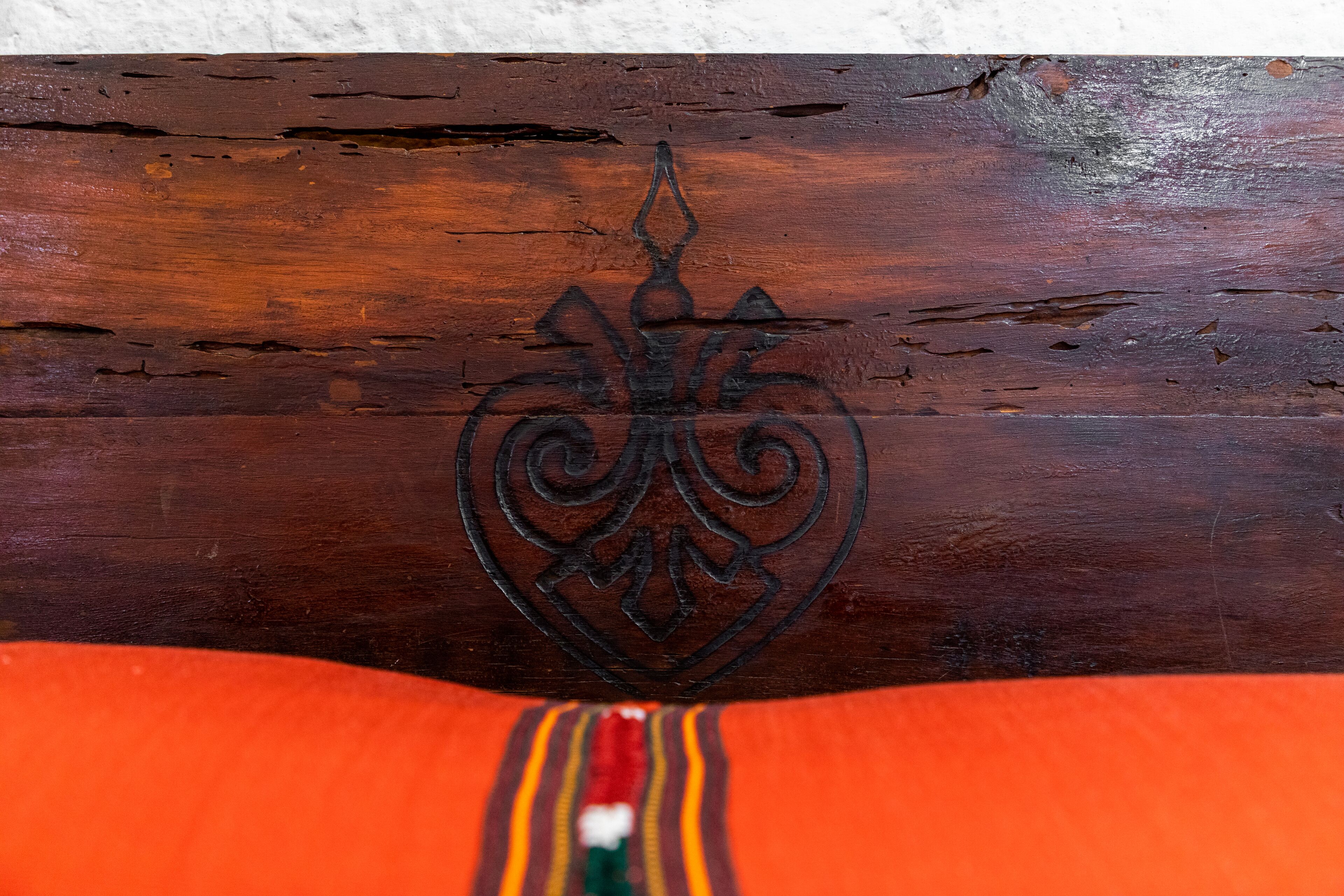 A wooden surface with a carved emblem.