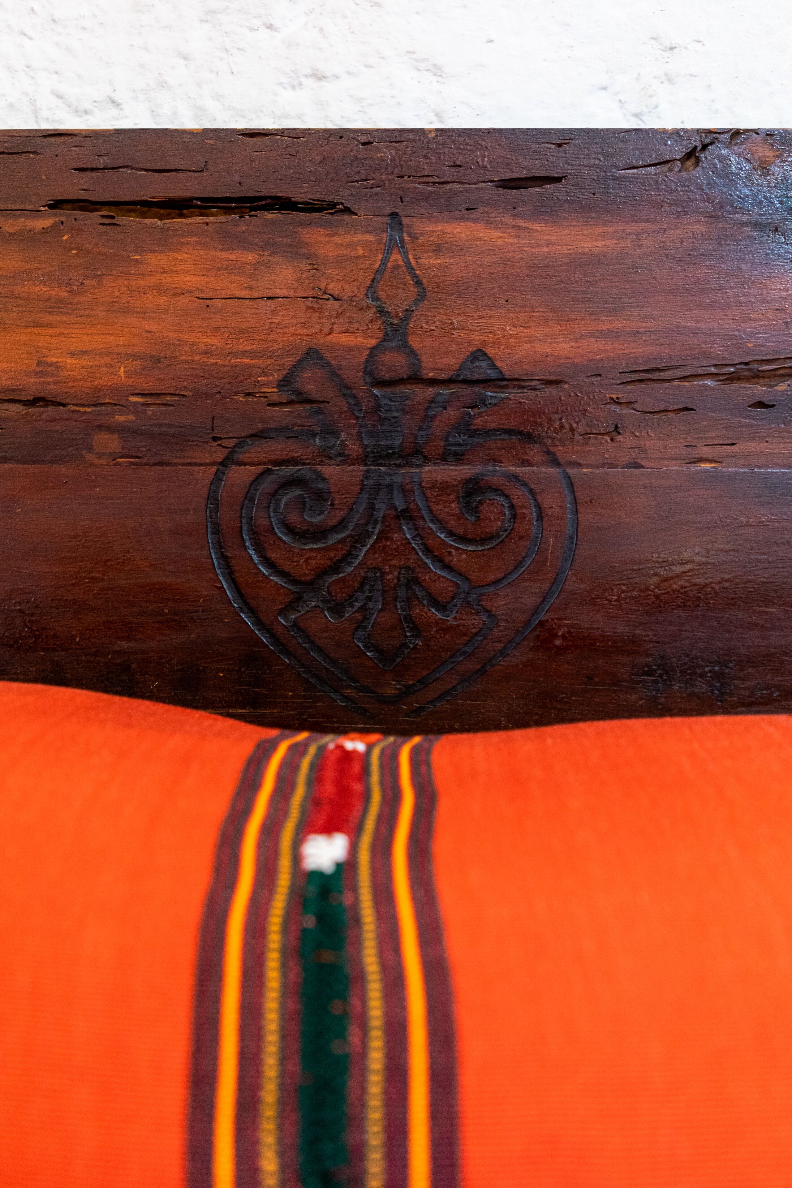 A wooden surface with a carved emblem.