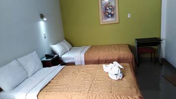 Habitación de hotel con dos camas, un escritorio y un cuadro en la pared.