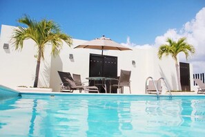 Piscina all'aperto, una piscina in terrazza, lettini